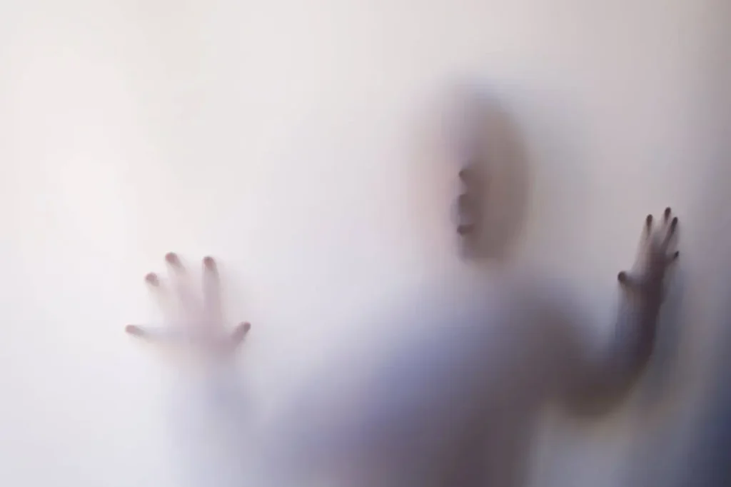 A figure seen through a white screen