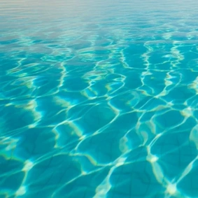 Água de piscina na cor verde-água com reflexos de luz.